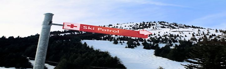 Red ski patrol sign on a snowy mountain